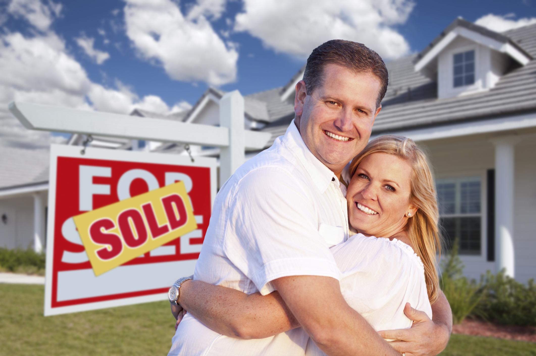 happy couple outside their sold house